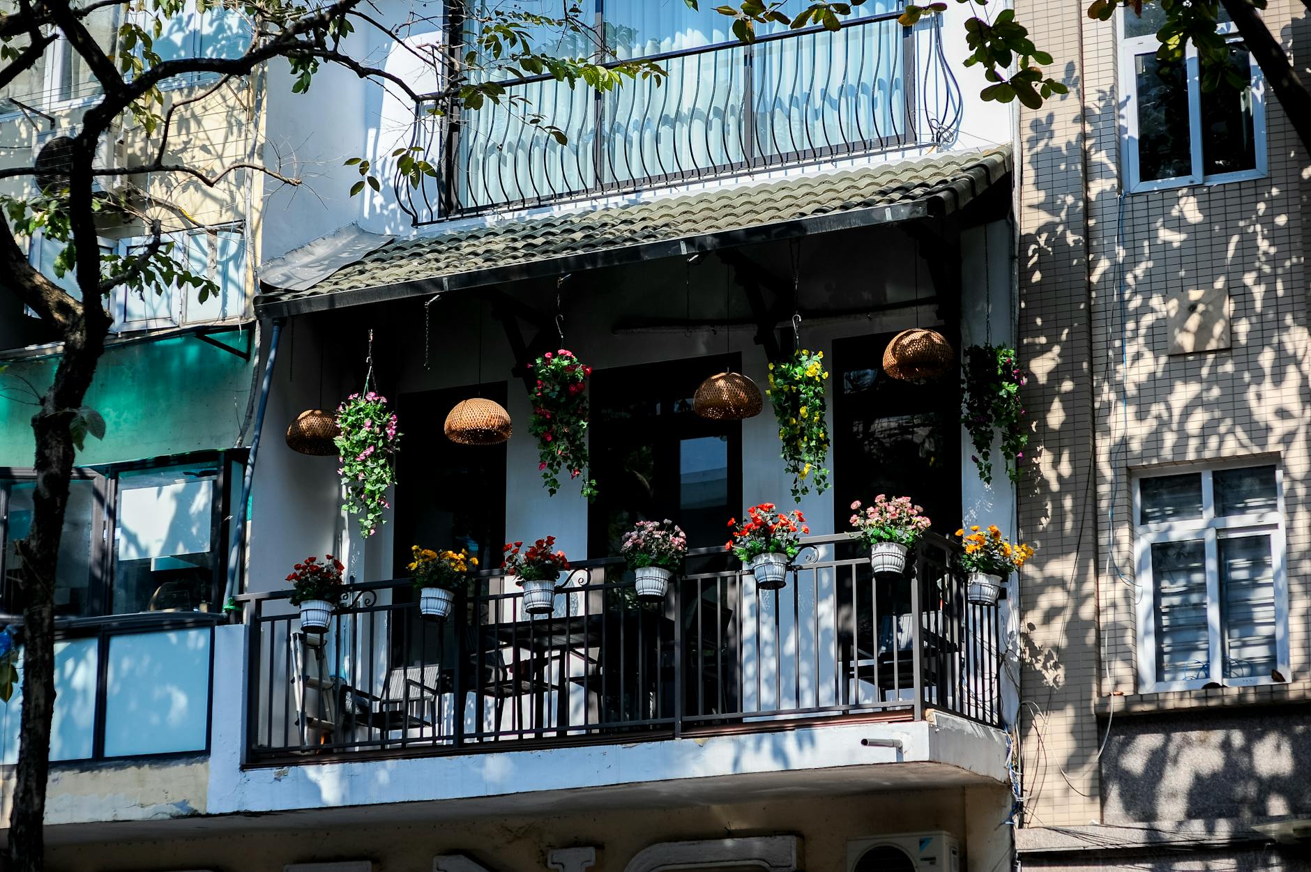 Fertige vertikale Pflanzwand aus Paletten auf einem Stadtbalkon mit üppigen Kräutern